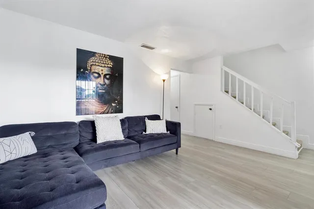 a living room with furniture and stairs