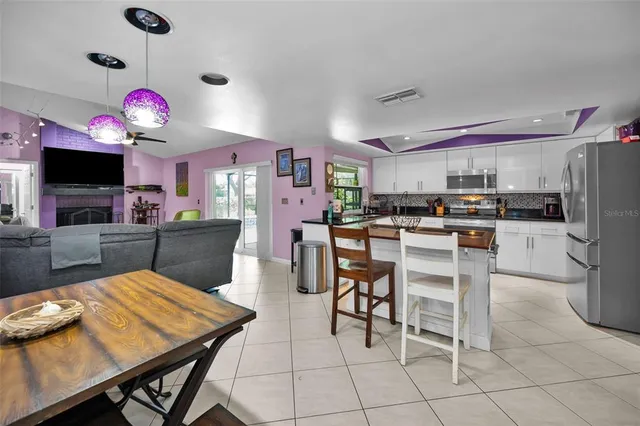 a kitchen with stainless steel appliances kitchen island granite countertop a stove a refrigerator a kitchen island a dining table and chairs