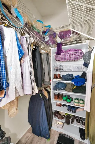 a view of walk in closet with clothes and shoes