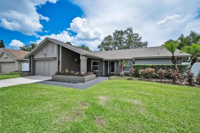 a view of a house with a yard and a garden
