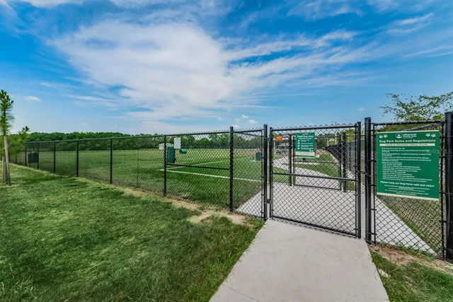 a view of green field with trees in the background