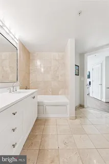 a bathroom with a tub sink and a mirror