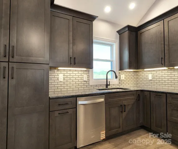 a view of a kitchen with a sink and wooden cabinets