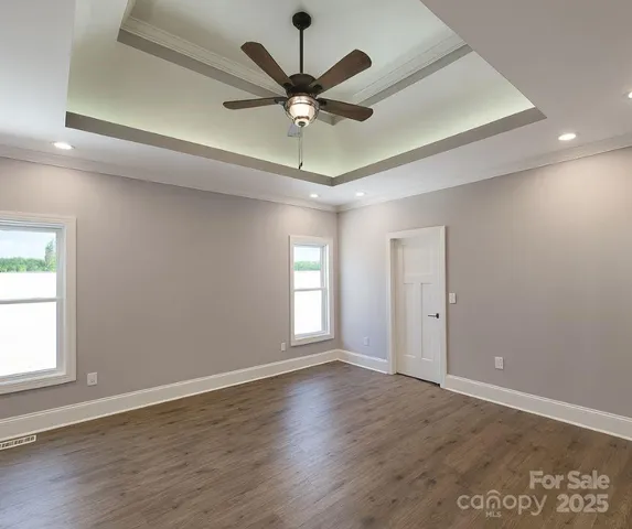 an empty room with ceiling fan and window