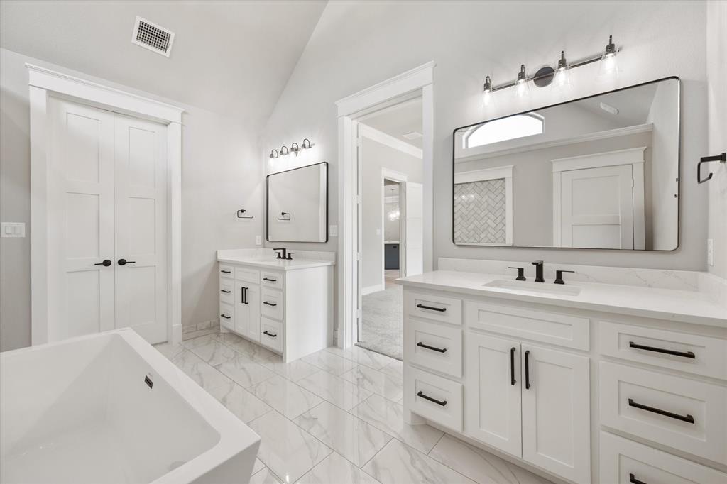 6610 Waggoner Way Midlothian, TX 76065 - Photo 22 of 40 Dual vanities with white cabinetry, quartz countertops, and matte black hardware