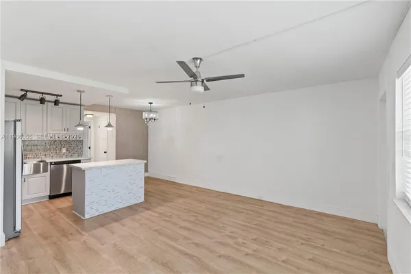 a view of a kitchen with a sink and a refrigerator