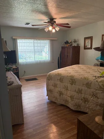 a bedroom with a bed and wooden floor