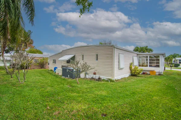 a view of a house with a yard and sitting area