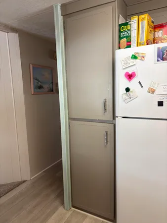 a white refrigerator freezer and a wooden floor
