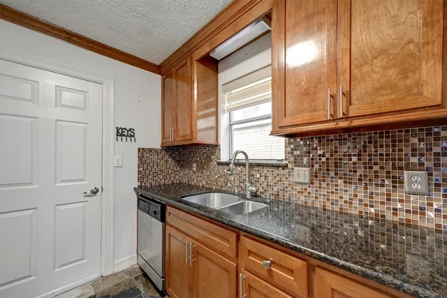 a bathroom with a granite countertop sink and a bathtub