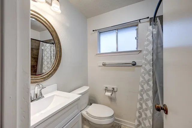 a bathroom with a toilet a sink and a mirror