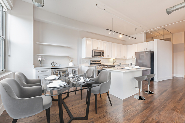 1000 West Adams Street, Unit 413 Chicago, IL 60607 - Photo 11 of 29 a kitchen with stainless steel appliances kitchen island granite countertop a sink a stove a refrigerator cabinets and chairs