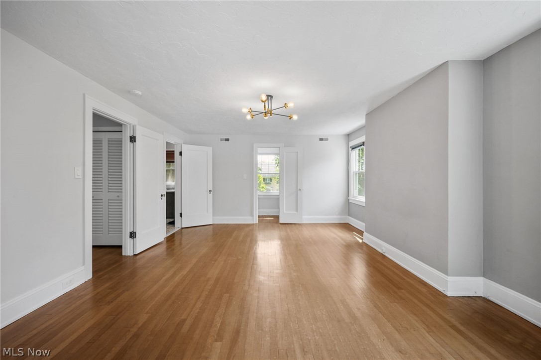 2924 Brighton Road Shaker Heights, OH 44120 - Photo 21 of 31 Unfurnished living room featuring a chandelier, wood finished floors, and baseboards