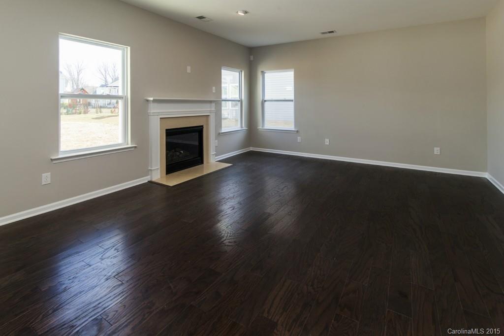 79475 Ridgehaven Road, Unit 43 Lancaster, SC 29720 - Photo 5 of 21 an empty room with wooden floor a fireplace and windows