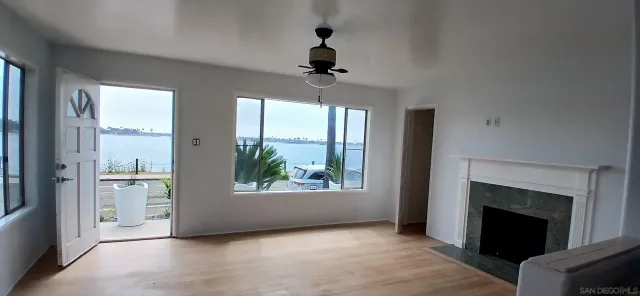 an empty room with windows and fireplace