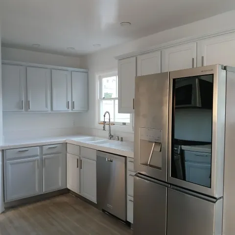 a kitchen with a refrigerator sink and cabinets