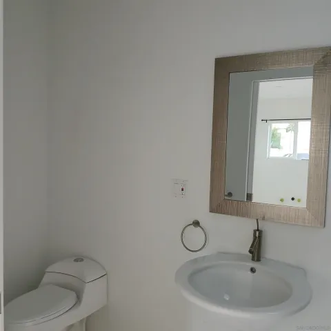 a bathroom with a toilet sink and mirror
