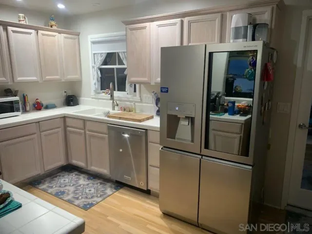 a kitchen with stainless steel appliances granite countertop a refrigerator and a sink
