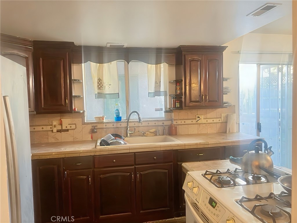 3600 Mountain, Unit 12F San Bernardino, CA 92404 - Photo 7 of 10 a kitchen with a sink stove and cabinets