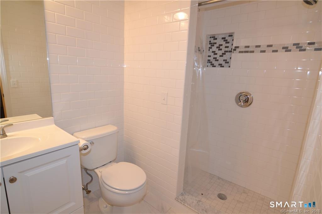 60 Central Boulevard Groton, CT 06340 - Photo 11 of 18 a bathroom with a granite countertop toilet and a shower