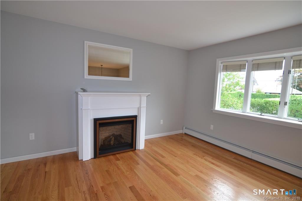 60 Central Boulevard Groton, CT 06340 - Photo 16 of 18 a view of empty room with wooden floor and fireplace