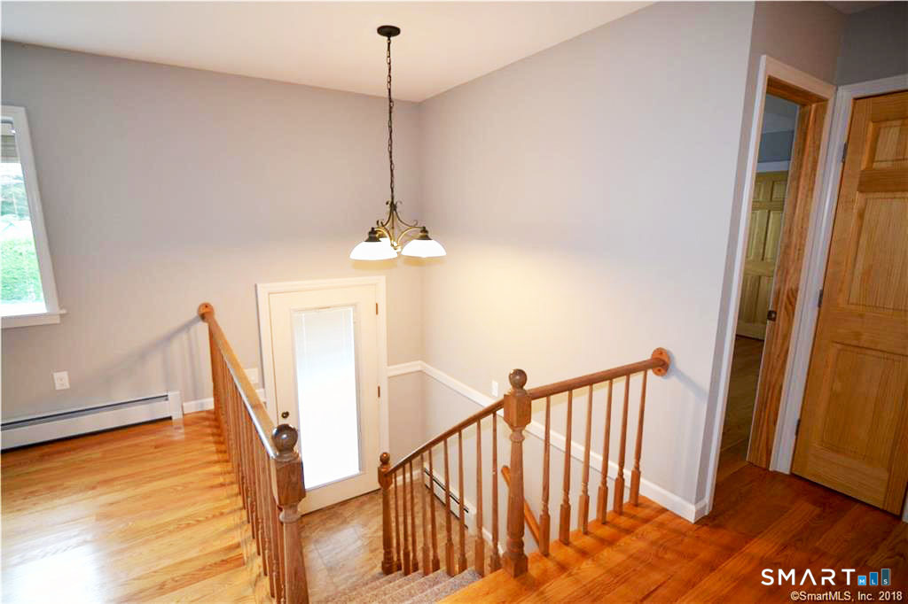 60 Central Boulevard Groton, CT 06340 - Photo 3 of 18 a view of a room with wooden floor staircase and windows