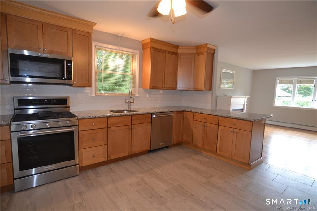 60 Central Boulevard Groton, CT 06340 - Photo 4 of 18 a kitchen with stainless steel appliances granite countertop a stove a sink and a microwave