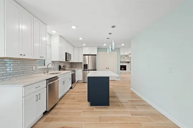 a large kitchen with stainless steel appliances granite countertop a stove and a sink