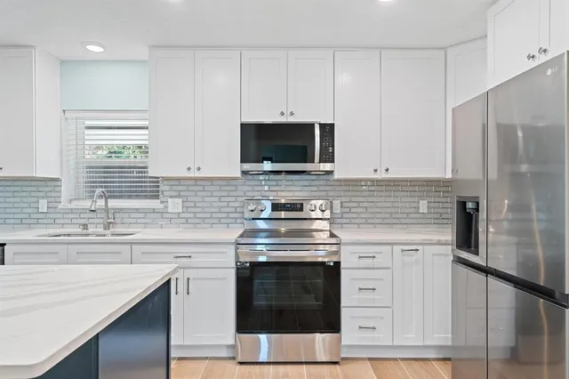 a kitchen with stainless steel appliances granite countertop a stove and a sink