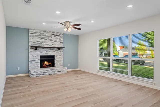 a view of an empty room with a fireplace and a window