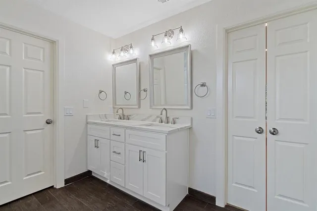 a spacious bathroom with a double vanity sink and mirror