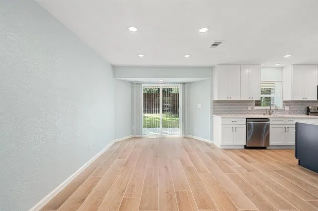 a view of a kitchen with wooden floor and electronic appliances
