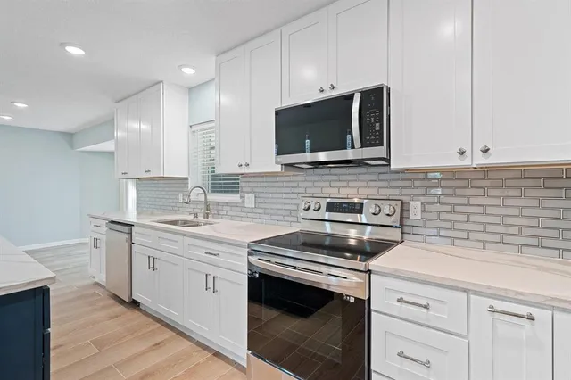 a kitchen with stainless steel appliances granite countertop a sink stove and microwave