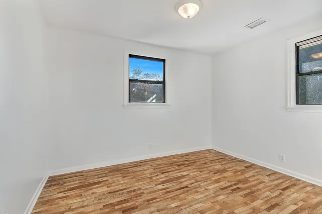 a view of empty room with wooden floor