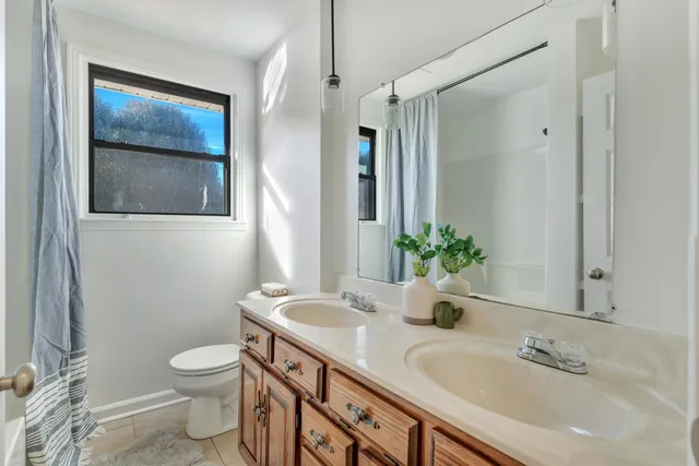 a bathroom with a granite countertop sink a toilet and a mirror