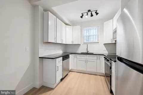 a kitchen with granite countertop a sink cabinets and window
