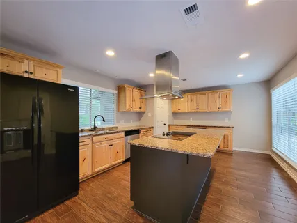 a kitchen with granite countertop a sink and a refrigerator