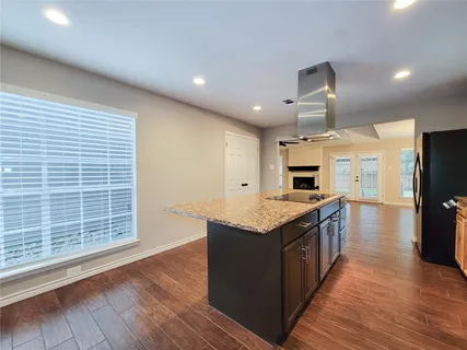 a kitchen with granite countertop a stove and a wooden floors