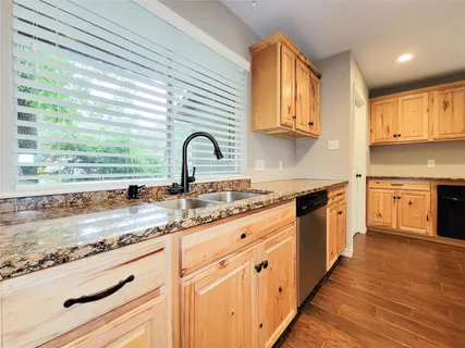 a kitchen with granite countertop white cabinets and appliances
