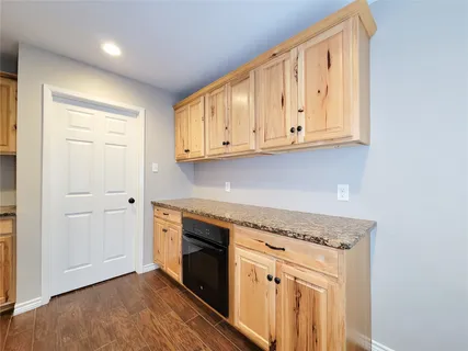 a kitchen with granite countertop white cabinets and stainless steel appliances