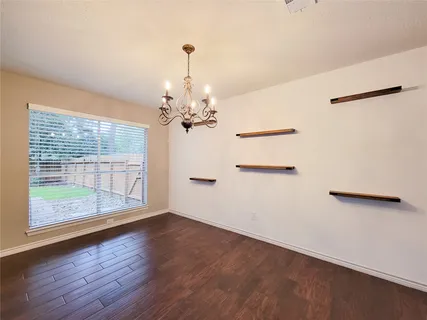 a view of a livingroom with a large window and wooden floor