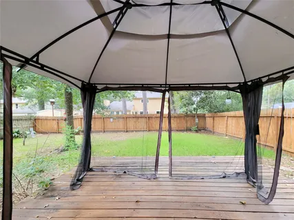 a view of a street with a yard and table under an umbrella