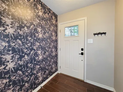 an empty room with wooden floor and a window