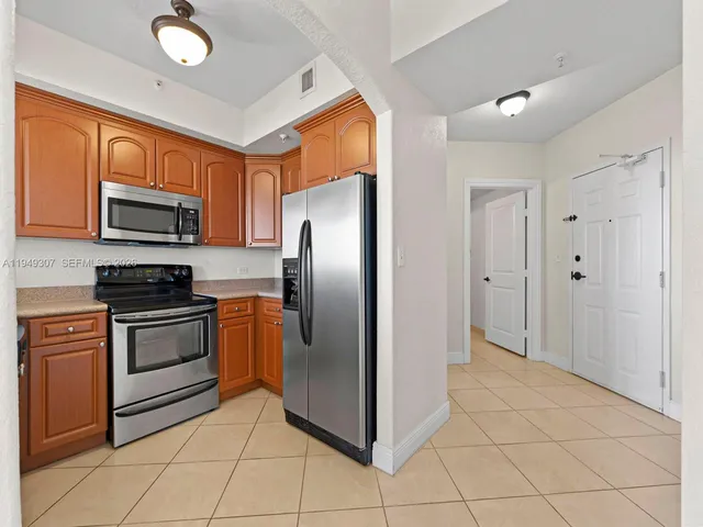 a kitchen with stainless steel appliances granite countertop a stove top oven a sink and dishwasher
