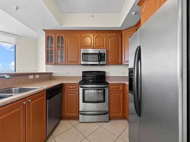 a kitchen with stainless steel appliances granite countertop a refrigerator a stove and a sink with granite countertops