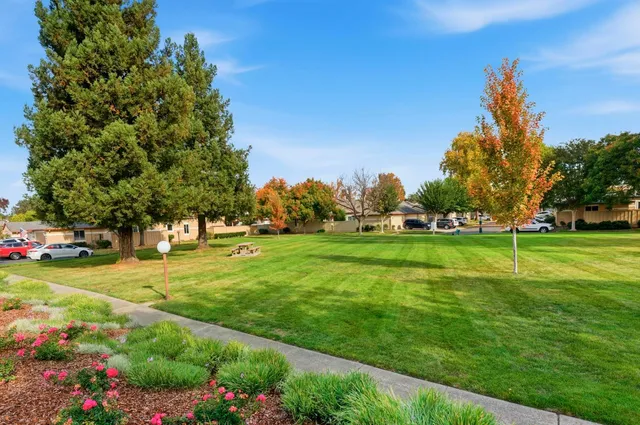 a view of sign board with buildings and trees around