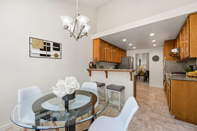 a kitchen with stainless steel appliances granite countertop a refrigerator a sink dishwasher a stove with wooden cabinets and floor