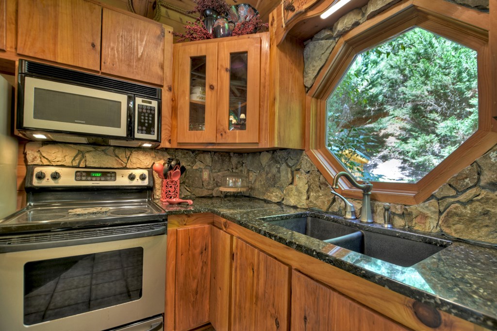 91 Dream Cove Road Cherry Log, GA 30522 - Photo 76 of 83 a kitchen with granite countertop a sink and a stove top oven