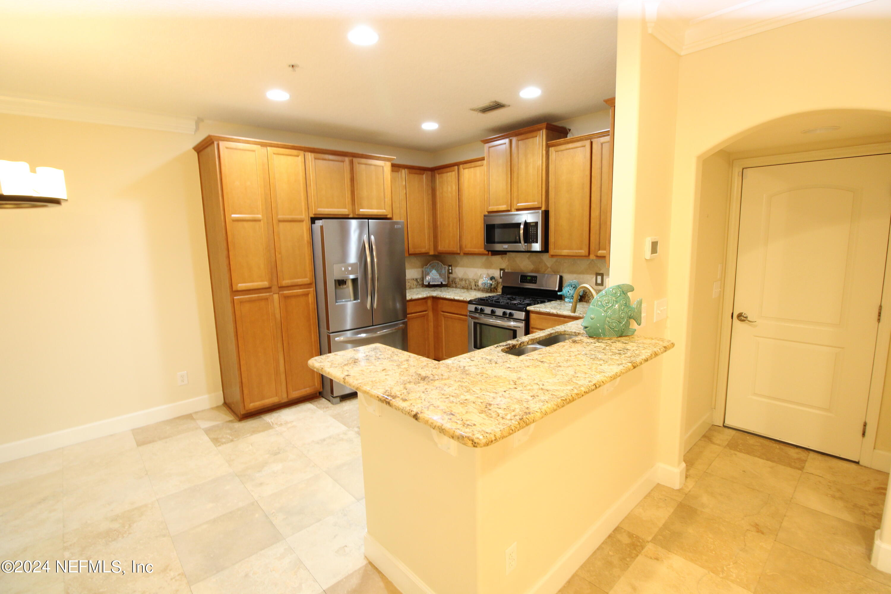 28 Grand Ravine Drive St. Augustine, FL 32086 - Photo 11 of 55 a kitchen with refrigerator a microwave a sink and a stove