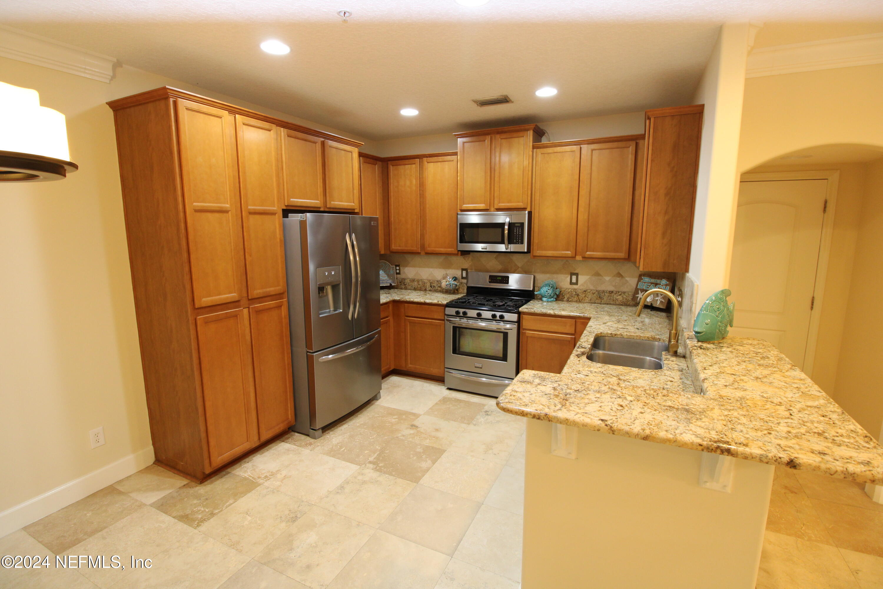 28 Grand Ravine Drive St. Augustine, FL 32086 - Photo 12 of 55 a kitchen with stainless steel appliances granite countertop a refrigerator sink and wooden cabinets